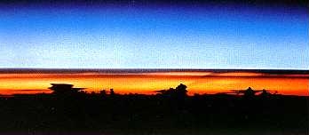 Weerhuisje.eu - De Dampkring - Een Chemische Deken - Onweerswolken bij zonsopgang, gezien vanuit de Spaceshuttle Atantis. De vlakke, aambeeldvormige wolkentoppen markeren de bovengrens van de troposfeer